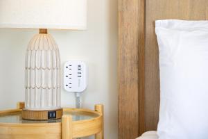 a lamp on a table next to a bed and a phone at Stylish Studio with Great Ocean Views & Near Beach! in Honolulu