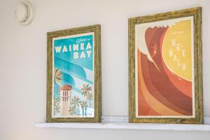 two framed posters on a shelf in a room at Stylish Studio with Great Ocean Views & Near Beach! in Honolulu