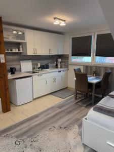 a kitchen with white cabinets and a table in a room at Große moderne Ferienwohnung mit Klimaanlage, Parkplatz inklusive TOP ! in Fürth