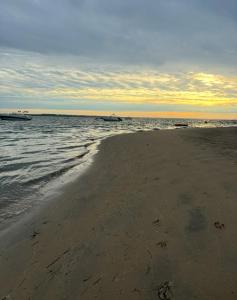 a sandy beach with two boats in the water at Maison cap ferret proche des plages in Lège-Cap-Ferret +7 photos