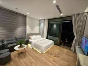 a bedroom with a bed and a couch and a tv at Luxury apartment with River view Landmark2 Ecopark in Kim Quan