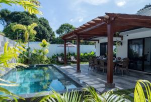 an outdoor dining area with a pool and a pergola at Paraluman, large Villa with pool in El Nido