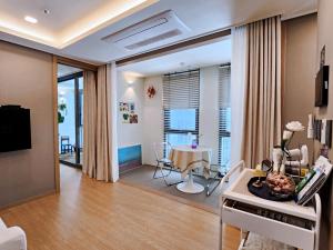 a living room with a table and a dining room at Haeundae Lamer Stay in Busan