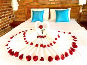 a bed with a swan made out of red roses at An Yen Resort in Phú Quốc