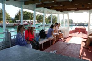 a group of people sitting on the back of a boat at Liberty Guesthouse Maldives in Mahibadhoo