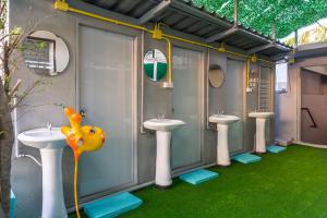 a bathroom with three sinks and three toilets at Love CNX Guesthouse in Chiang Mai
