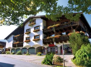 un bâtiment avec des boîtes de fleurs sur son côté dans l'établissement Haus Central, à Kössen