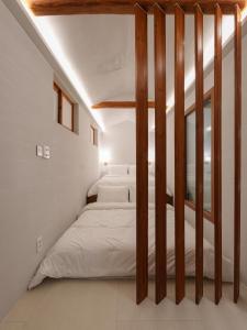 a bedroom with white walls and a bed with wooden posts at Bukchon Hanok - 'Yul Jae' The access code is sent by message in Seoul