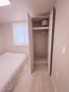 ein kleines Schlafzimmer mit Bett und Kleiderschrank in der Unterkunft 리사 스테이 로맨틱 프라이빗 테라스, 무료주차, 2룸 in Daegu