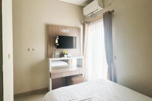 シドアルジョにあるHomestay Harmony Syariah RedPartner Near Juanda T2のベッドとテレビと窓のある寝室