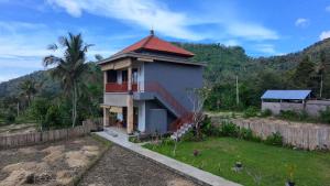 a house with a red roof and a fence at Tirta Unda Sidemen in Sidemen