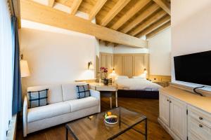 a living room with a couch and a bed at ERMITAGE Wellness- & Spa-Hotel in Gstaad