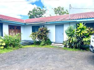 a blue and white house with a red roof at Melissa cozy corner in Tafuna