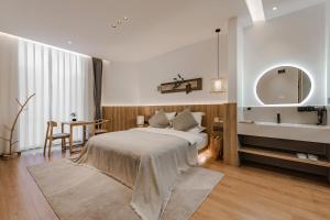 um quarto com uma cama e um banheiro com uma pia em 墨弦苑智能轻奢民宿 喜洲镇海舌公园店 em Dali