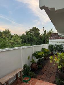 a balcony with a bench and a fence with plants at 10mins to BKK airport 3BR Group Stay in Bangkok