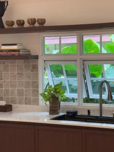 a kitchen with a sink and a window with a plant at 10mins to BKK airport 3BR Group Stay in Bangkok +65 photos