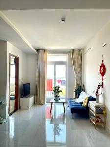 Kinh DinhにあるApartment 2BR 2WC Hacom Phan Rangの青いソファとテーブルのあるリビングルーム