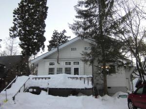 a white house with snow in front of it at Hakuba Haven Lodge in Hakuba