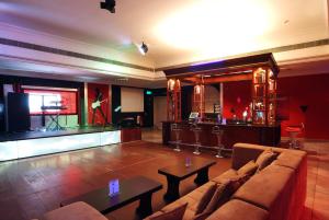 uma sala de estar com um sofá e um bar em Al Wadi Hotel em Sohar