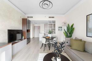 a living room with a couch and a table at Silkhaus Canalside 1BR at Water's Edge in Yas Island in Abu Dhabi