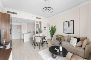 a living room with a couch and a table at Silkhaus Canalside 1BR at Water's Edge in Yas Island in Abu Dhabi