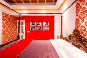 a red bedroom with a bed with a red wall at The Corner Courtyard in Kolkata
