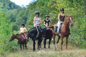 a group of people riding horses in a field at Camping Le Pré Cathare in Lavelanet