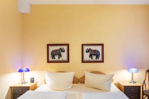 une chambre avec deux lits et deux tableaux au mur dans l'établissement Ferienwohnung Tannenblick 1-2, à Oberhof