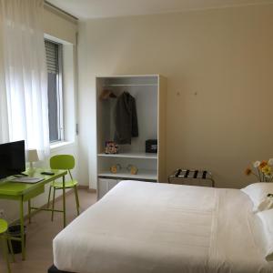 1 dormitorio con 1 cama blanca grande y escritorio en B&B Hotel Milano Ornato, en Milán