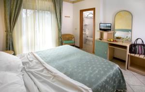 a bedroom with a bed and a desk and a bathroom at Hotel Boccaccio-free parking- in Milano Marittima