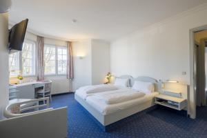 Postel nebo postele na pokoji v ubytování Hotel Gautinger Hof - Ruhig im 5-Seen-Land nahe S-Bahn und München + 11 fotografií