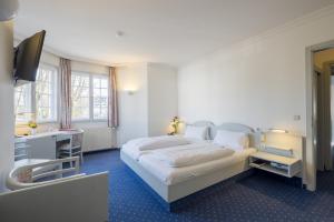 a hotel room with a bed and a television at Gautinger Hof in Gauting