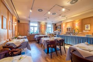 a restaurant with tables and chairs in a room at Hotel Gautinger Hof - Ruhig im Fünf-Seen-Land nahe S-Bahn und München in Gauting