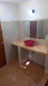 a bathroom with a red sink and a mirror at Happy House in Tanti