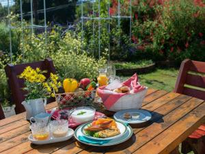 una mesa de picnic con comida y una cesta de fruta en La Mirador, en Kamogawa