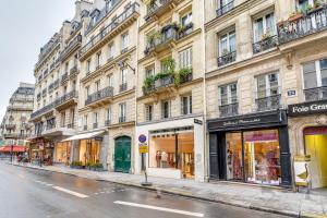 a city street with shops on the side of a building at Sweet Inn - Etienne Marcel in Paris
