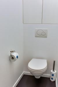 uma casa de banho com um WC branco e um rolo de papel higiénico em Sweet Inn - Etienne Marcel em Paris