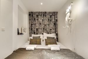 ein Schlafzimmer mit einem Bett in einem weißen Zimmer in der Unterkunft Sweet Inn - Etienne Marcel in Paris