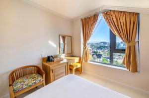 a bedroom with a bed and a desk and a window at Cerasoi Boutique Villa Dalat in Da Lat