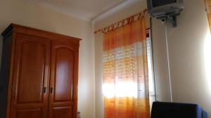 a room with a wooden cabinet and a window at Pousada Farol do Portinho in Vila Praia de Âncora