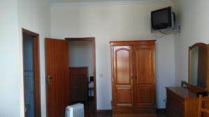 a room with a cabinet and a tv on the wall at Pousada Farol do Portinho in Vila Praia de Âncora +41 photos