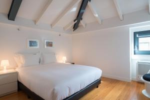 Un dormitorio con una gran cama blanca y una ventana en FLH Bairro Alto Luxus Flat, en Lisboa
