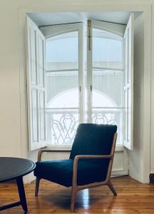 einem Stuhl vor einem Fenster in der Unterkunft La Casa de María Pita in A Coruña