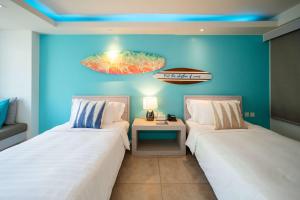 a room with two beds and a table in it at Zenmaya Oceanfront Phuket, Trademark Collection by Wyndham in Patong Beach +78 photos