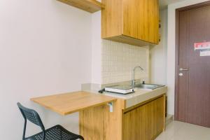 タンゲランにあるComfy and Nice Designed Studio Parkland Avenue Apartment By Travelioのキッチン(シンク付)、カウンター(椅子付)