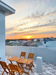 un tavolo e delle sedie su un balcone con un tramonto di Hải Hưng Homestay - Đảo Phú Quý a Cù Lao Thu