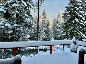Ein verschneiter Garten mit schneebedeckten Bäumen und einem Zaun in der Unterkunft Riverfront Chalet Near Skiing, Lakes, Mtns & Leavenworth in Leavenworth + 87 Fotos