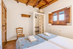 a bedroom with a bed and a chair in a room at Casa Rural El Corral in La Zubia +22 photos