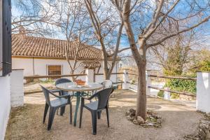 a table and chairs in front of a tree at Casa Rural El Corral in La Zubia