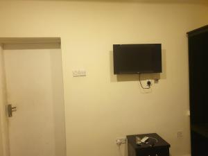a flat screen tv on the wall of a room at Jowey Homestay in Abuja